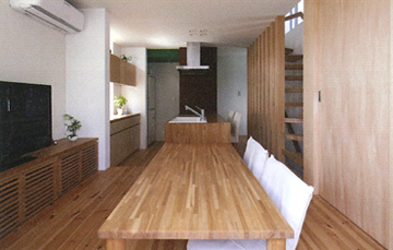 アイランドキッチンを中心としたＬＤＫ。床座のリビングの床を上げて、視線の高さの違いを補っている。